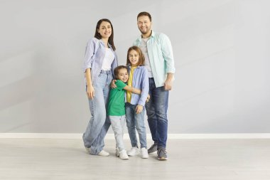 Mutlu aile günü eğlencesi, evde birlikte durmak, ebeveynler, tatlı çocuklar portre sarılmak, neşeli bir çift küçük aktif çocuklarla gülüyor oğlu, kızı boş oturma odasında, akrabaları birlikte.