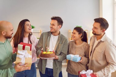 Mutlu yıllar mum pastası, hediyeler kutlama, arkadaş canlısı aile portresi, genç arkadaşlar özel etkinlik için birlikte parti. Gülümseyen insanlar toplanıp eğleniyorlar ve büyük mutluluklar diliyorlar.