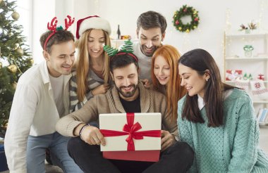 Arkadaşlar Noel 'i ya da yeni yılı kutlamak için evde birlikte bir hediye kutusu açarlar. Şenlikli bayram anı bir parti sırasında paylaşılır ve grubun sıcak ortamdaki neşesini ve beraberliğini vurgular..