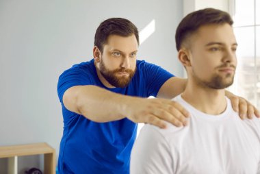 Önlem alan genç bir adam modern hastane ofisinde osteopat profesyonel bir doktor. Kayropraktik uzmanı omurga ağrısı ya da başka sorunları olan hastalara yardım ediyor. Sağlık kontrolü, tıp konsepti.