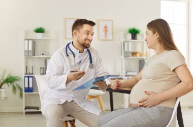 Genç hamile kadın kliniği ziyaret eden doktoru muayene ediyor, tıp jinekoloğu muayene ediyor, anne ve doğum öncesi sağlık hizmetleri, sağlıklı hamilelik, test, açıklama, açıklama, sonuçları netleştirmek,