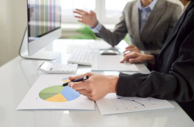 İki erkek meslektaşım finans pazarlama araştırması, pasta grafikleri ve diğer grafikleri analiz etmekle, muhasebe istatistikleri, planlama satışları, dijital istatistiksel analiz için yazılım kullanmakla meşguller.