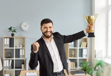 Heyecanlı mutlu genç adam portresi resmi giysiler giymiş kameraya bakıyor iş hayatında başarı ödülü ya da şirketteki en iyi çalışan ödülünün sahibi..