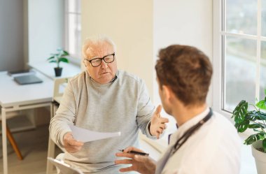 Soran kıdemli adam, yaşlıların sağlık ve sosyal hizmetleri, genç doktor, erkek hemşire muayene sırasında kontrol, sağlık hastane sistemi, klinikteki hastalarla profesyonel fizik tedavi
