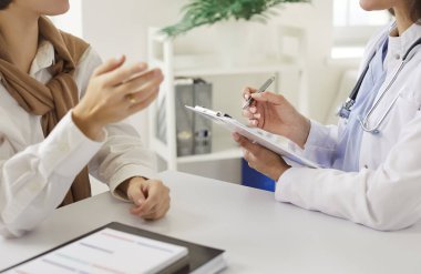 Kadın doktoru dikkatle dinlerken ve muayene sırasında not alırken gördüm. Hekim ya da kardiyolog hasta sağlığı sorunlarını anlamaya ve ele almaya odaklanmıştır..