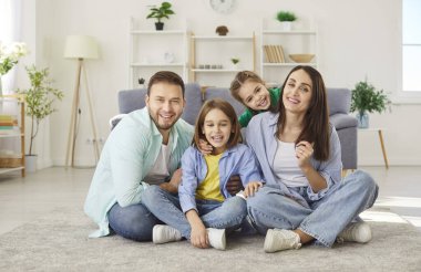 Mutlu, gülen bir aile birlikte, aileler, şirin çocuklar, sıcak zeminde birlikte oturmaktan keyif alan bir portre, neşeli bir çift, küçük, aktif çocuklarla gülüyor, oğlum, kızım oturma odasında.