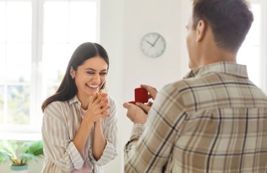 Adam şaşırmış bir kadına evlenme teklif ediyor, evde yüzük hediye ediyor. Aşk, romantizm, güçlü tutku ve sevgiyle dolu bir an. Bağlanıyorlar ve evliliğe doğru adım atıyorlar..