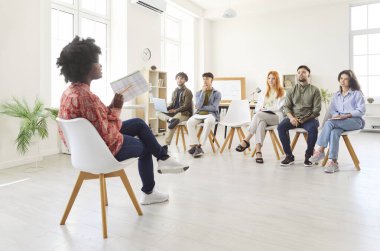 İş kadını bir ofis ortamında meslektaşları için bir sunum ya da toplantı düzenler. Bir grup insan iş stratejilerini tartışıyor ve işle ilgili projelerde işbirliği yapıyor.