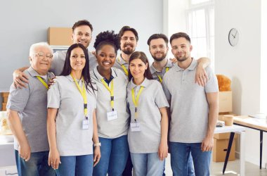 Çeşitli gönüllülerden oluşan bir ekip. Küçük bir yiyecek deposunda gri üniformalı, kimlik etiketli bir grup beyaz ve Afro-Amerikan insan. Hayır işi, kâr amacı gütmeyen kuruluşlar konsepti.