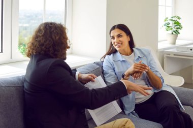 Genç iş adamları ofiste toplanıp kanepede oturup konuşuyorlar. Mutlu ve kendinden emin gülümseyen iki işçi finans belgelerini tutarak birlikte çalışıyor. Takım çalışması, iş planı tartışması.