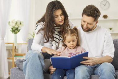 Evde sevgi dolu bir aile, sevimli çocuklara kitap okumayı öğreten bir çift ebeveyn, komik masallar anlatan, kanepede dinlenen, çocukları kucaklayan, hafta sonları edebiyat hobilerinden zevk alan bir çift.