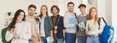 Not defterleri ve sırt çantalarıyla yan yana yan yana duran mutlu üniversite öğrencileri, arkadaş canlısı grup arkadaşları, sınavları başarıyla geçtikten sonra tatmin oluyorlar. Eğitim kavramı