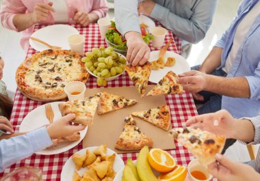 Masada aile yemeği, evde birlikte yemek yemek, partide buluşmaktan keyif almak, İtalyan fast food pizzası yemek, ebeveynler, büyükanne ve büyükbabalar, hafta sonu çocuk toplantısı. 