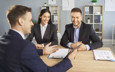 İş arkadaşları ya da müşteriler, takım çalışması, işbirliği ve anlaşma odaklı bir iş toplantısı için ofiste toplanırlar. Bu grup insan ortak iş hedefleri için çalışıyor..