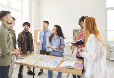 Mutlu, gülen, başarılı iş adamlarından oluşan bir grup günlük giysiler içinde iş projelerini tartışıyorlar ve iş yerinde işe başlıyorlar. Şirket işi ve takım çalışması kavramı.