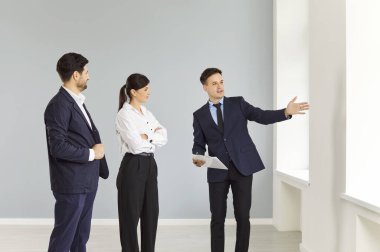 Bir emlakçı bir grup insana boş bir ofis gösteriyor. Ev satmak ve kiralamak, gayrimenkule yatırım yapmak. Tasarımcının proje istemcileriyle görüşmesi, danışma 