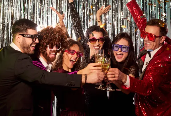 Genç arkadaş grubu diskoda eğleniyor. Partide kadeh tokuşturup şampanya içiyorlar. Takım elbiseli mutlu insanlar gümüş folyo arka plandaki şirket partisinde başarıyı kutluyorlar..