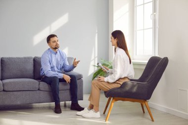 Kadın televizyon ya da gazete muhabiri erkek bir misafirle röportaj yapıyor. Genç bir kadın ve bir adam bir sandalyede ve kanepede oturup konuşuyorlar. Talk show, TV, basın, gazetecilik, kitle iletişim araçları
