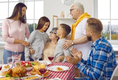 Şükran Günü aile yemeği. Çok nesilli aile Şükran Günü 'nü kutlarken ve birlikte vakit geçirirken eğleniyor. Büyükannem torunlarını kucaklıyor. Tatiller ve kutlama konsepti.