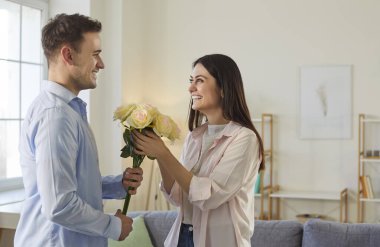 Adam bir kadına çiçek veriyor. Sevgililer Günü 'nde romantik bir anın tadını çıkaran genç ve mutlu bir çift. Koca ya da erkek arkadaş, karısına ya da kız arkadaşına bir buket sarı gül verir. Aşk konsepti