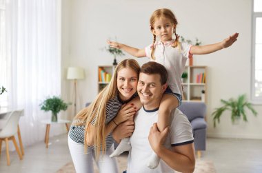 Mutlu, neşeli aile portresi, gülümseyen, küçük tatlı kızlarıyla birlikte gülümseyen, modern oturma odasında poz veren hafta sonları dinlenmek, ilgilenmek ve sevmek için dinlenen, eğlenen