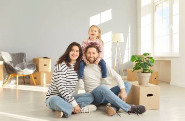 Aile yeni bir daireye taşınmayı seviyor, mutlu anne, baba, mukavvaların yanında sevimli bir çocuk, heyecanlı ev alıcısı kutuları taşıyor, yeni ev taşınmasını organize ediyor, daha iyi bir yer için ikametgah değiştiriyor, bağımsızlık