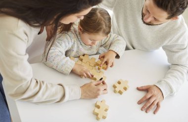 Ailesi ve küçük kızı boş zamanlarını evde ahşap bir yapbozla oynayarak geçiriyorlar. Bu eğlenceli, eğlenceli oyunu birlikte oynuyorlar, neşeli ve eğlenceli bir atmosferde bağ kuruyorlar..