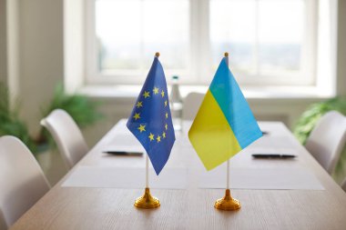 Avrupa Birliği ve Ukrayna bayrakları toplantı odasında masaya oturmuş uluslararası müzakereleri, birliği ve ortaklığı simgeliyor. Diplomasi kavramı, ilişkiler. anlaşma ve işbirliği.