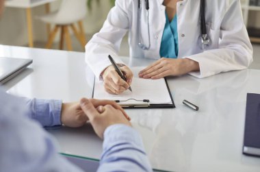 Kadın doktor, pratisyen hekim klinikteki hastalara danışmanlık yapan, pratisyen hekim, muayene sonuçlarını hastalarla görüşen, tedavi planını paylaşan, terapist.