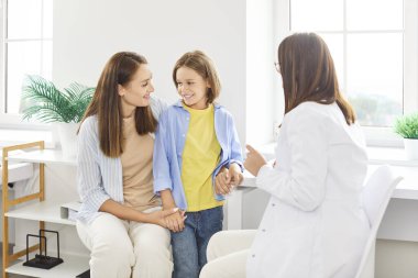 Pediyatrist kadın, aile doktoru, klinikte çocuğa yardım eden aile doktoru, hastanedeki kadın tıp doktoru, çocuk ve anne babaya danışan, klinikte tedavi gören genel pratisyen, profesyonel 