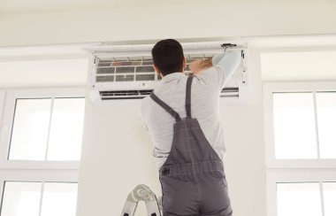 Havalandırma ünitesini kuran ya da takan işçiler, sıcak, soğuk hava odasının sıcaklık kontrolünü tamir eden işçiler, optimal cihaz performansı için ayarlama, ev ortamı, ideal iklim sağlama