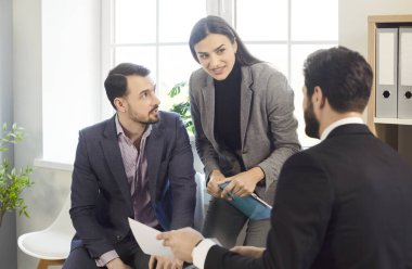 Üç kendine güvenen şirket çalışanı konuşuyor ve tartışıyorlar, yeni projeleri ve girişimleri değerlendiriyorlar, şirketleri analiz ediyorlar. Ofisteki genç iş adamları. Takım çalışması konsepti.