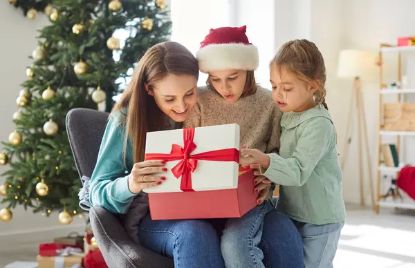 Heyecanlı bir aile, çocuklu bir anne Noel hediyelerini evde birlikte açarken eğleniyor çocuklar geleneksel yeni yıl tatillerini kutluyor.