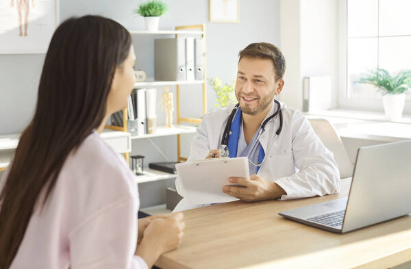 Добрый мужчина врач консультирует женщину, чтобы объяснить, обмен результатами лабораторных тестов на здоровье молодой пациентке, объясняя медицинское страхование, встреча в офисе клиники для планирования, ответить на вопросы