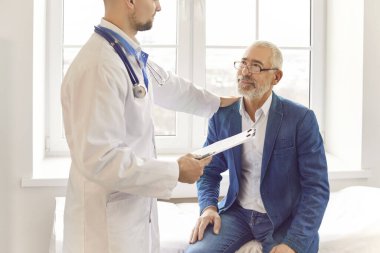 Hastanedeki yaşlı hastaya el desteği, kıdemli müşteri hizmetleri, pratisyen hekim bakımı, klinikte olgun bir adamla tanışma, yardım, yardım...