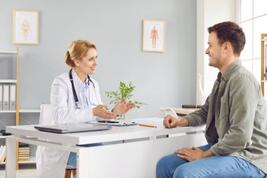 Hastaneye gittiği sırada erkek bir hastaya tıbbi danışmanlık yapan bir kadın doktor ya da hemşire. Sağlık hizmetleri konuşmasında kapsamlı bir sağlık kontrolü ve bakımı ele alınıyor..