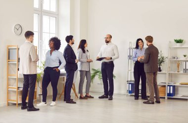 Ofiste dikilirken iletişim kuran çok kültürlü iş adamlarından oluşan bir grup. Molada iş yerinde iş arkadaşları konuşuyor. Etkin dinleme becerileri, etkili iletişim