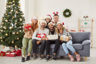 Mutlu yıllar, mutlu noel kutlaması hediyeleri taşıyan arkadaşlar birlikte yeni yıl arifesini kutluyorlar, çeşitli insanlar heyecan içinde evlerinde eğleniyorlar ağaç yakınında. 