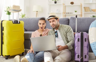 Bavulların arasında yerde oturan ve oturma odasındaki dizüstü bilgisayara bakan genç çift için sürpriz oldu. Yaz kıyafetleri içinde şok olmuş gezginler, tatil planlama fiyatları karşısında hayrete düşmüşler, biletleri ayırtmışlar.