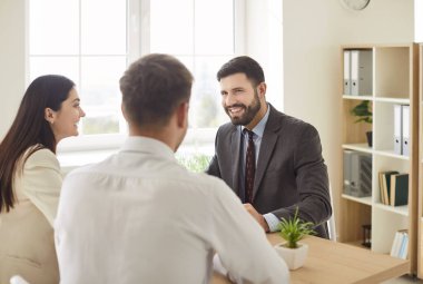 Kendine güvenen üç genç iş adamından oluşan bir grup toplantıda bir iş projesini tartışıyor. İş arkadaşları ve şirket çalışanları ofiste masasında oturan erkek meslektaşlarıyla konuşuyor. Takım çalışması konsepti.