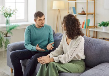 Evdeki kanepede oturan ve karısıyla tartışan sinirli bir adam. Stresli aile çifti gergin bir konuşma yapıyor. Konuşma sırasında kızgınlıklarını ve hayal kırıklıklarını dile getiriyorlar. İlişki sorunları kavramı.