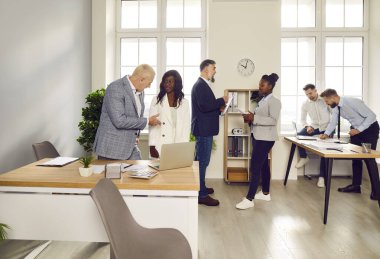 Bir grup iş adamı ve kadın işyerlerinde konuşuyor. Şirket çalışanları büroda çalışıyor, iş ve iş projelerini tartışıyorlar. Takım çalışması konsepti.