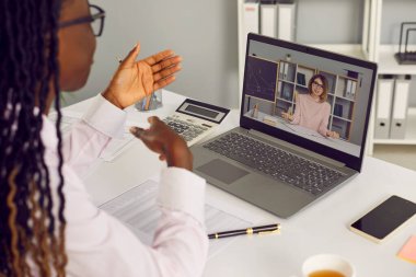 Afrikalı Amerikalı kadın muhasebeci, iş danışmanı, çevrimiçi okul müdürü veya profesyonel işe alım müdürü dizüstü bilgisayardaki video mesajı yoluyla matematik öğretmeniyle maaşı tartışıyor.