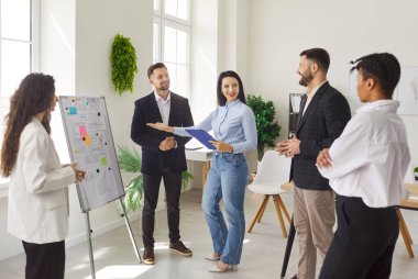 Bir grup kendine güvenen iş adamı modern ofiste bir çember içinde durmuş iş projelerini ya da girişimleri tartışıyorlar. İş arkadaşları ve şirket çalışanları bir toplantıda iş arkadaşlarıyla konuşuyor..