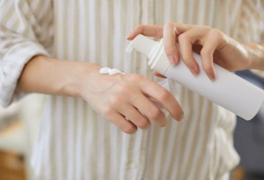 Kadının eline cilt bakımı ve korunması için nemlendirici krem sürerken yakın plan. Kadın vücudu için günlük güzellik ve yaşlanmayı önleyici tedavi uyguluyor. Kozmetik ve kozmetik konsepti.