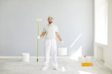 Evde tadilat yaparken elinde boya rulosu ve kova tutan mutlu bir ressam ya da profesyonel bir işçinin portresi. Ev geliştirmeye ve yenilenmiş bir alan yaratmaya adanmıştır..