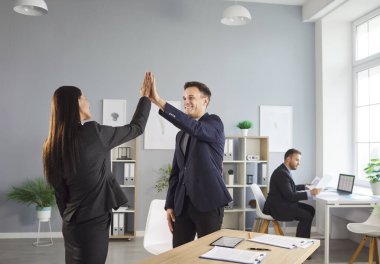Mutlu iş bürosu çalışanları beşlik çakıyor, dost canlısı meslektaşları selamlıyor, galibiyeti kutluyor, iş tanıtımı, başarı ve modern ofiste buluşan insanları tebrik ediyor.