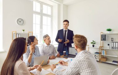 Bir grup hevesli ofis çalışanı bir masada oturur ve yakın planda patronu dinler. Toplantıdaki iş adamları çalışma süreçlerini tartışıyor. Şirket gündemi, bölüm beyin fırtınası.