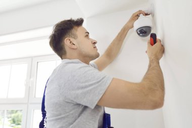 Elektrikçi bir eve ya da ofise güvenlik kamerası yerleştiriyor. İşçi, güvenlik ve izleme sisteminin geliştirilmesi için gerekli işlevselliği sağlar..