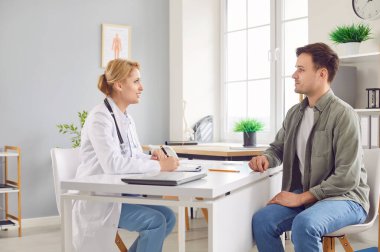 Ofiste erkek hastaya danışmanlık yapan kadın ciddi doktor, tedaviyi açıklayan doktor, erkek sağlık hizmetleri, pratisyen hekim ya da hekim kliniği için danışmanlık yapan doktor